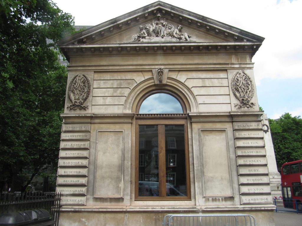 Attendees at meetings often long for the end of the debate but committee members of the National Railway Heritage Awards had a special reason for anticipating the end of the trust’s committee meeting on Wednesday 26 September as the date had been set for the official unveiling of the plaque made to Euston Tap Ltd for the restored windows in the two lodges at Euston. The plaque, presented at the annual ceremony held at Merchant Taylors’ Hall on 6 December 2017, recognised the project to restore the windows of the late 19th century lodges being given the Supporters Award. As was said at the ceremony ‘It has been a thoroughly worthwhile enterprise for which all involved can take great credit.’ 	One of the more entertaining facets of the event was the ‘curtain’ used to hide the plaque before its unveiling by Chris Smyth, from the Heritage Railway Association (one of the award’s sponsors) – this was one of the T-shirts normally worn by the staff behind the bar.
